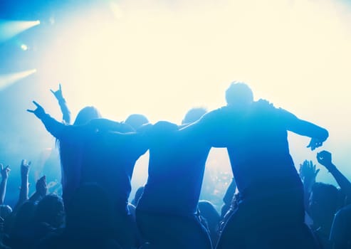Nightclub, people and audience with silhouette or lights for party, concert or rave festival with dance and dj. Disco, psychedelic event and performance with entertainment, crowd and hand gesture.