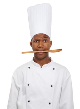 Portrait, chef and black man with spoon in mouth isolated on white studio background. Person, kitchen utensil and serious face of cooking professional, baker or restaurant worker in catering service