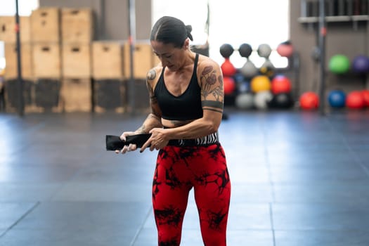 Woman putting on a belt to prevent injuries while lifting