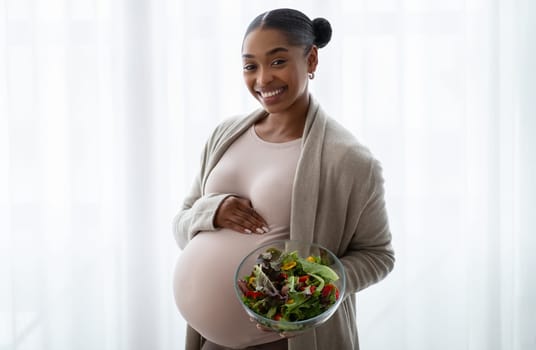 Smiling african american pregnant woman showing her lunch