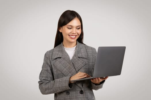 Smiling businesswoman using laptop, technology at work