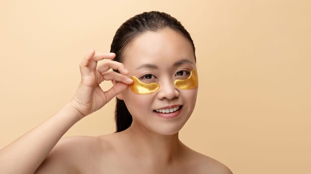 Happy chinese naked lady put patches under eyes, enjoy procedure
