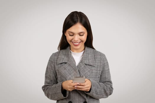 Smiling caucasian woman using smartphone chatting with clients