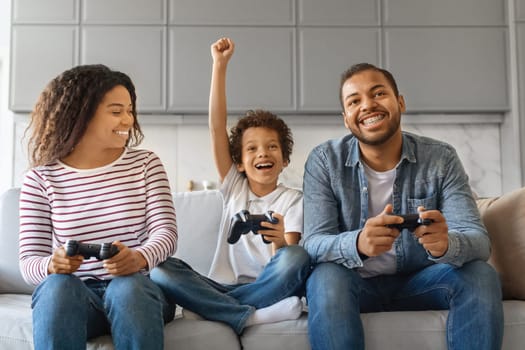 Family Pastime. Cheerful Black Parents Playing Video Games With Son At Home