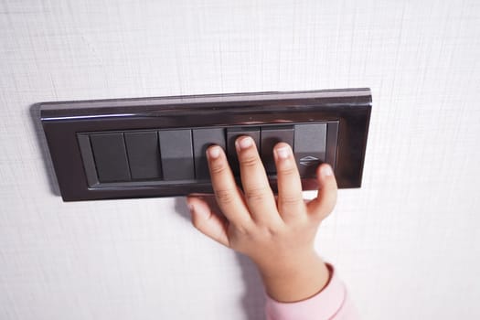 child finger turning on lighting switch with copyspace
