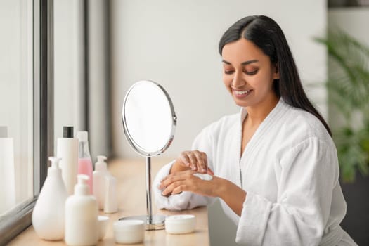 Pretty indian woman enjoying her morning body care routine
