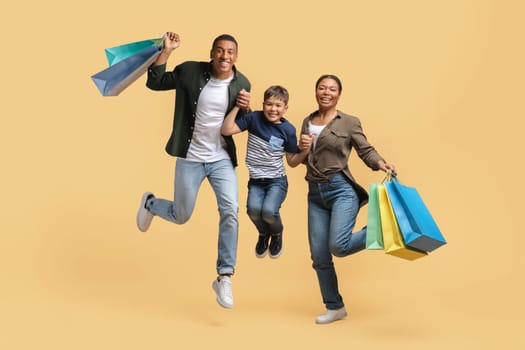 Overjoyed african american family jumping with purchases