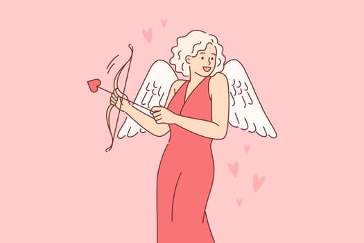 Cupid woman dressed up with wings for valentine day, uses with arrow and bow to seduce boyfriend