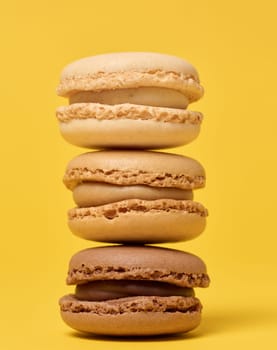 Stack of chocolate macarons on yellow background