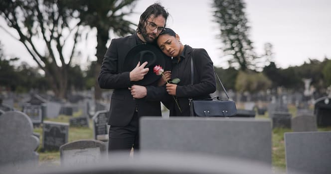 Couple, sad and mourning at tomb of graveyard, funeral and pay respect together outdoor. Death, grief and man and woman at cemetery by casket, empathy and interracial support to console at tombstone