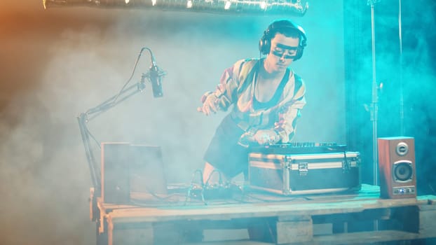 Musical specialist mixing records at turntables on stage