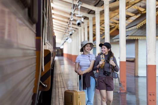 two young beautiful female women at station to catch train for their vacation together