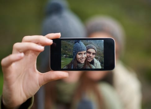 Couple, hiking and smartphone for selfie in nature, camera and capture moment in outdoors. People, happy and picture for memory and exploring wilderness, trekking and photograph for social media