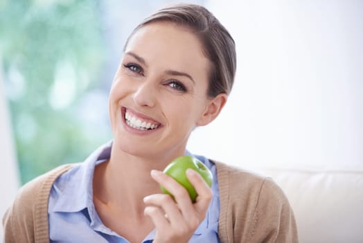 Portrait, home or happy woman with apple for healthy or balanced diet with nutrition, smile or vitamins. Face, relax and vegan person eating fresh fruit, food or fibre for organic wellness in lounge