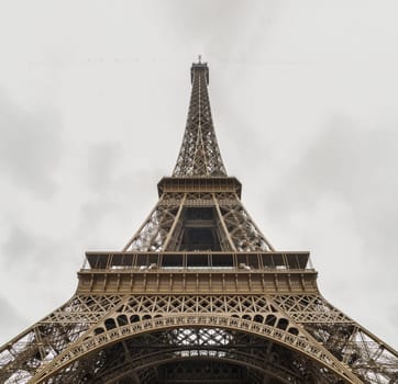 Low angle shot of Famous Eiffel tower iron structure with white sky background.