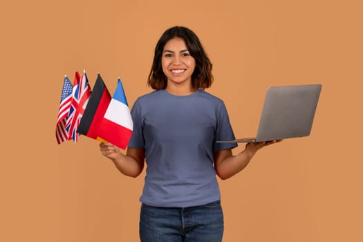 Cheerful young arab woman student with many different flags, laptop