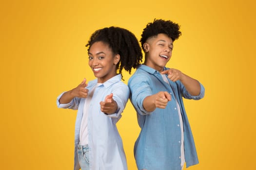 Young African American woman and man in denim give enthusiastic thumbs up