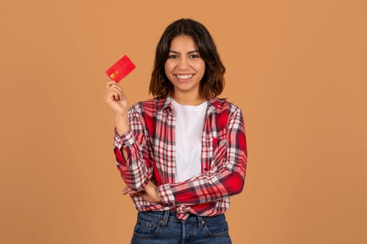 Positive young middle eastern lady showing bank credit card