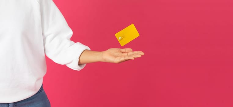 Magical Finance. Young woman levitating yellow credit card with her palm