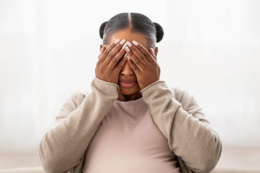 Closeup of african american pregnant lady crying at home