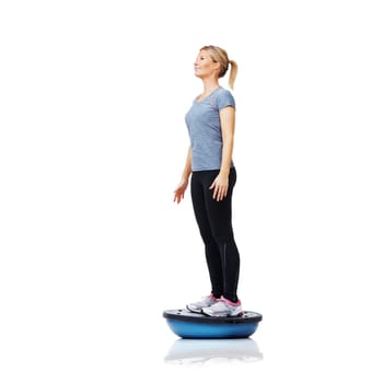 Woman, ball and standing in fitness for balance, exercise or workout on a white studio background. Young active female person or athlete on half round object for health and wellness on mockup space