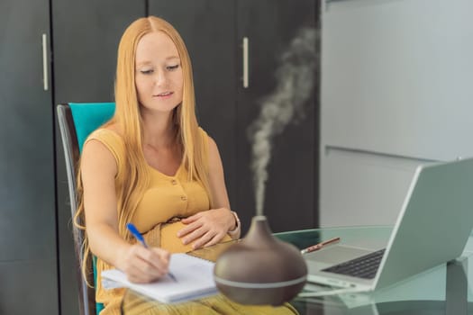 Expectant woman enhances work environment, using an aroma diffuser for a soothing atmosphere during pregnancy