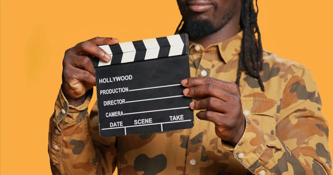 African american film producer using clapperboard