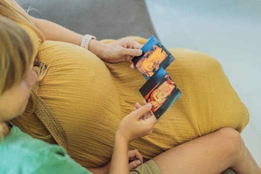 Expectant mother tenderly shares the joy of her unborn baby with her son, showing him heartwarming ultrasound photos of his soon-to-arrive little brother