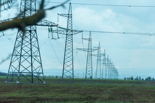 High voltage towers with sky background. Power line support with wires for electricity transmission. High voltage grid tower with wire cable at distribution station. Energy industry, energy saving