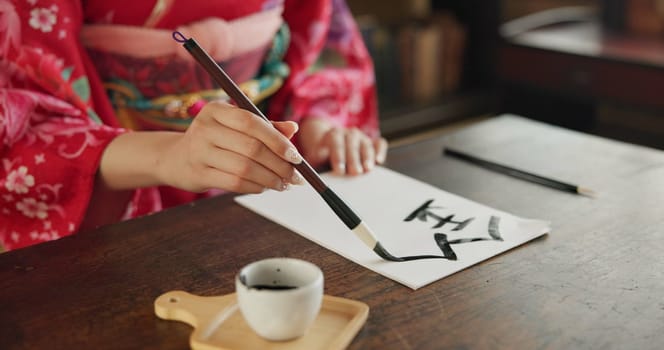 Ink, Japanese writing and hands of woman in home for traditional script, paper and documents. Creative, Asian culture and person with vintage paintbrush tools for calligraphy, font and text in house