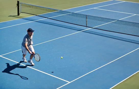 Sport, man and tennis on court with fitness, competition and performance outdoor with match and energy. Power, athlete and ball on turf for training, health and racket with skill, game or hobby