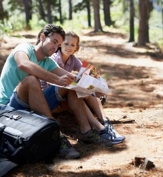 Couple, travel in forest and reading map for direction, documents guide or location information on a journey. Lost people on a break with infographics, brochure of nature and destination for trekking