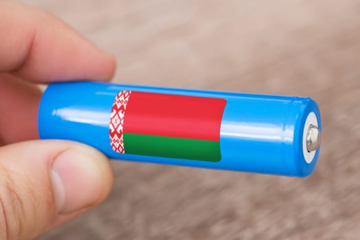 Rechargeable battery with flag of Belarus in hand of a man