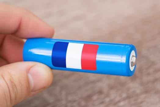 Rechargeable battery with flag of France in hand of a man