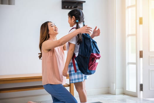 Loving mother and schoolgirl with backpack before first day