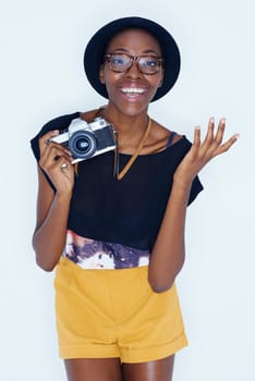Black woman, photographer and portrait in studio with happiness, creativity and camera for talent and creative artist career. Young person, smile and face for photoshoot and lens by white background