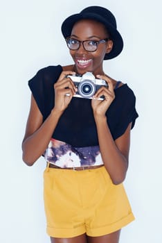 Black woman, photographer and portrait in studio with smile, creativity and camera for talent and creative artist career. Student, happiness and face for photography and glasses by white background