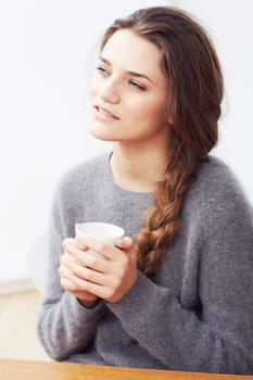 Woman, coffee cup and thinking with smile, memory and ideas with vision, future and relax at desk. Girl, person and remember in cafe with drink, tea or coco with decision, question or wonder by table