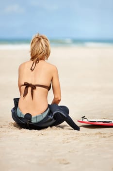 Surfing, beach and back of woman with surfboard for water sports training, wellness and fitness by ocean. Nature, relax and person on sand for adventure on holiday, vacation and hobby by sea waves