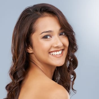 Portrait, beauty and curly hair of happy woman in salon in studio isolated on a grey background. Face, smile or hairstyle of model in makeup cosmetics, hairdresser and treatment for care of skin glow.