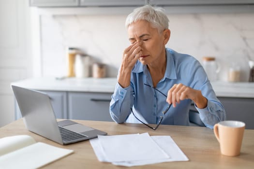 Senior Woman Having Sore Eyes And Migraine After Computer Indoor