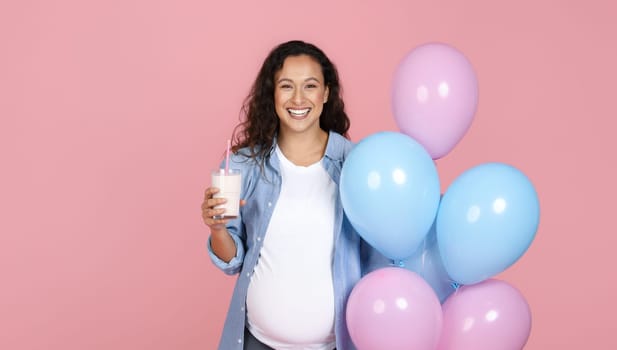Smiling pregnant young woman with glass of milk