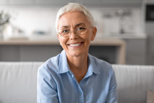 Closeup portrait of happy senior lady with stylish eyeglasses indoor