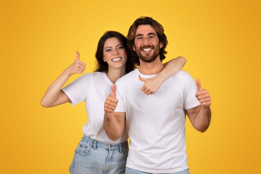 Joyful couple giving thumbs up and embracing, showcasing approval and happiness with bright smiles