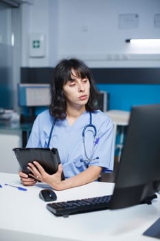 Nurse reviewing files with technology