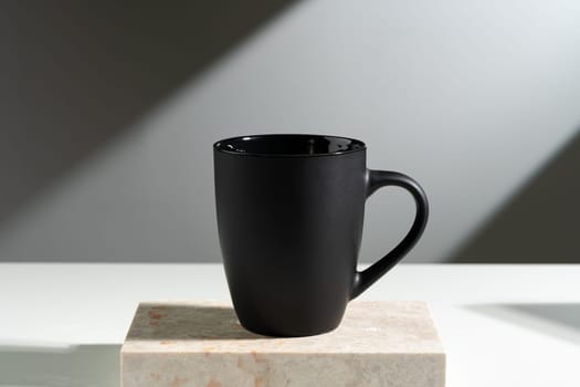 Black cup shadow sun light against gray background