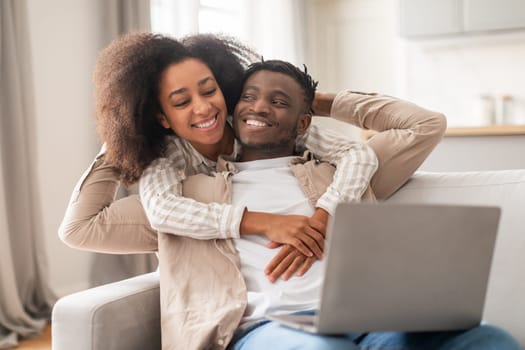 Black Family Couple Hugging Watching Movie On Laptop Online Indoors