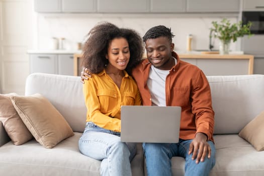 African American couple watching movie on laptop in living room