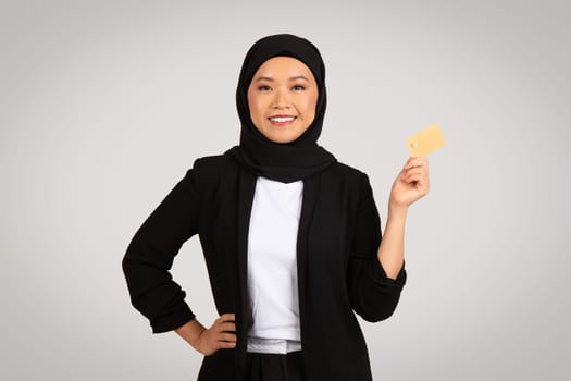 A poised young woman wearing a hijab and a professional black blazer