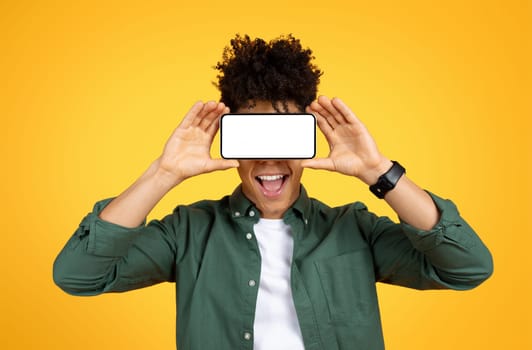 Black guy holding smartphone with white screen over his eyes